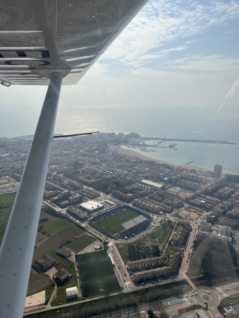 Vista aérea de Palamós y la Costa Brava tomada desde un avión ligero, mostrando el litoral mediterráneo y la zona residencial en 2026.